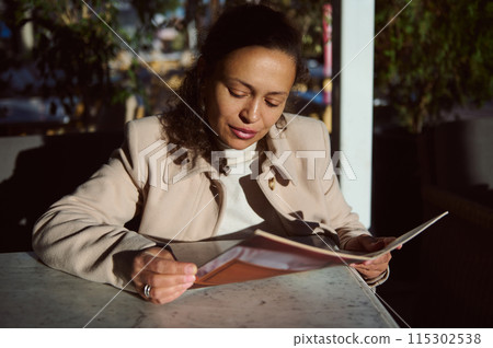 Woman reading a menu at an outdoor cafe 115302538