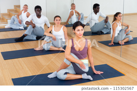 Adult people exercising during yoga class in fitness center Adult people exercising during yoga class in fitness center 115302567