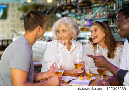 Diverse friends talking and smiling at a pub Diverse friends talking and smiling at a pub 115302689