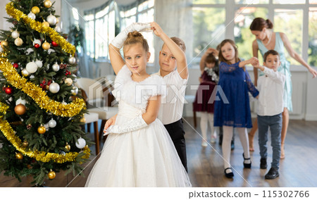 Viennese waltz performed by beautifully dressed children near Christmas tree 115302766