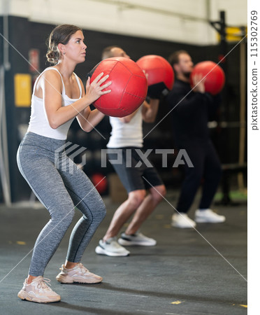Girl performing intense cross workout with medicine ball Girl performing intense cross workout with medicine ball 115302769