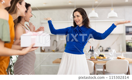 Three women have arrived for birthday celebration and presenting gift to birthday woman Three women have arrived for birthday celebration and presenting gift to birthday woman 115302814