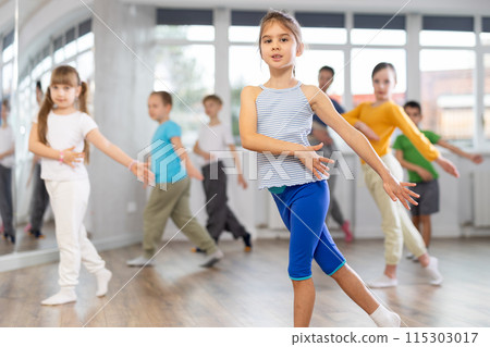Happy smiling preteen boys and girls practicing dance, with female trainer in dance hall 115303017