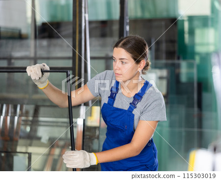 Female technician inspecting double glazed sealed units in workshop Female technician inspecting double glazed sealed units in workshop 115303019