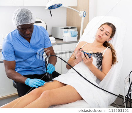 Cosmetologist reducing cellulite on the hips of a female patient Cosmetologist reducing cellulite on the hips of a female patient 115303101