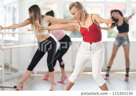 During lesson, woman learn to move and perform dance in heels with women companions 115303130