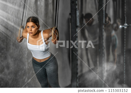 Young woman training on gymnastic rings 115303152