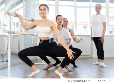 Elderly woman teacher corrects female dancers 115303228