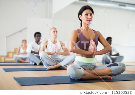 Group of people practicing yoga in dance hall 115303528