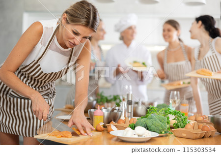 Young woman cutting raw chicken breast Young woman cutting raw chicken breast 115303534