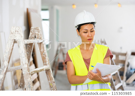 Woman engineer checking documents during repair works Woman engineer checking documents during repair works 115303985