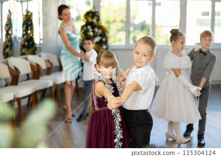 Little children in festive clothes dance foxtrot dance while celebrating Christmas 115304124