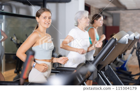 Young woman exercising on treadmill in gym Young woman exercising on treadmill in gym 115304179