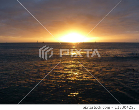 Dramatic Sunset over the clouds and reflecting on the Pacific ocean on the water of Waikiki Dramatic Sunset over the clouds and reflecting on the Pacific ocean on the water of Waikiki 115304253