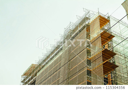 Construction scaffoldings with dust protection cover and scaffolding providing platforms Construction site of modern building. 115304356