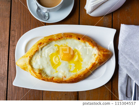 Boat-shaped Adjarian khachapuri with melted cheese, butter and egg yolk 115304557