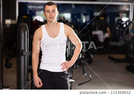 Sportive young man posing in gym 115304632
