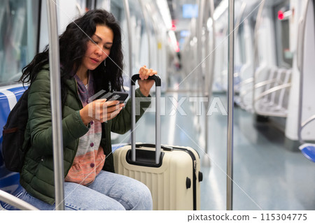 Woman passenger using phone in subway car Woman passenger using phone in subway car 115304775