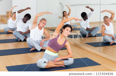 Group of sporty people practicing yoga positions during training 115304936