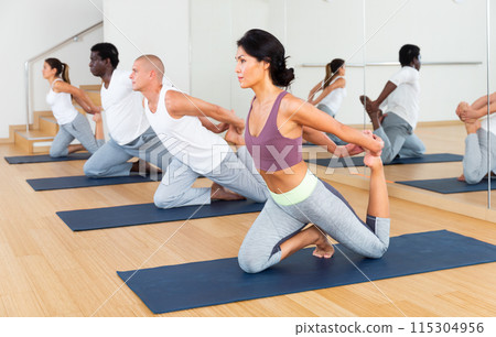 Multiethnic group of young people practicing yoga Multiethnic group of young people practicing yoga 115304956