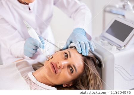 Young woman undergoing radiofrequency skin tightening procedure in cosmetic clinic Young woman undergoing radiofrequency skin tightening procedure in cosmetic clinic 115304976