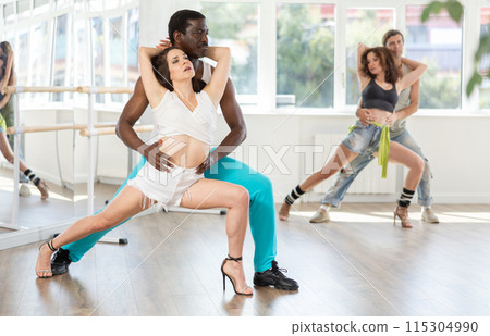 Man enjoying passioned merengue with female partner in latin dance class Man enjoying passioned merengue with female partner in latin dance class 115304990
