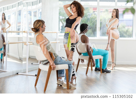 Woman performing sensual lap dance with man on chair at group rehearsal Woman performing sensual lap dance with man on chair at group rehearsal 115305102