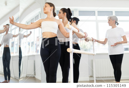 Elderly woman teacher corrects female dancers Elderly woman teacher corrects female dancers 115305149