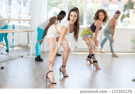 Female dancer practicing jazz-funk dance in studio with group 115305279