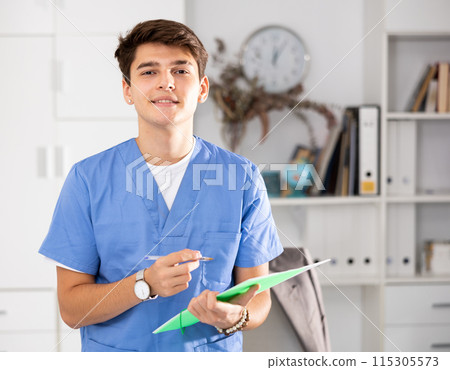 Portrait of promising male doctor working in a clinic and being in resident office Portrait of promising male doctor working in a clinic and being in resident office 115305573