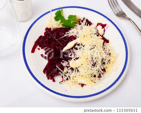 Fresh beetroot and cheese salad served on white plate and decorated with parsley sprigs 115305631