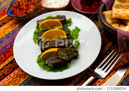 Turkish sarma from rice wrapped in grape leaves served with lemon Turkish sarma from rice wrapped in grape leaves served with lemon 115306034