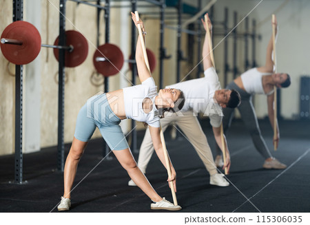 Young woman doing warm-up with stick 115306035