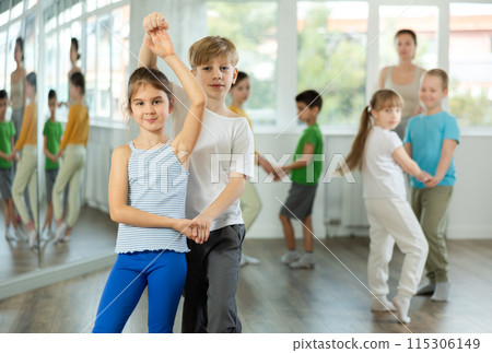 Girl paired up with boy and training to perform slow couple dance, rehearse performance. 115306149