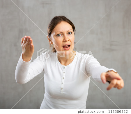 Indignant adult woman girl gesturing in studio Indignant adult woman girl gesturing in studio 115306322