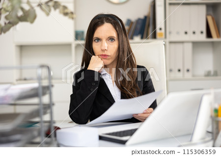 Portrait of woman office worker doing paperwork Portrait of woman office worker doing paperwork 115306359