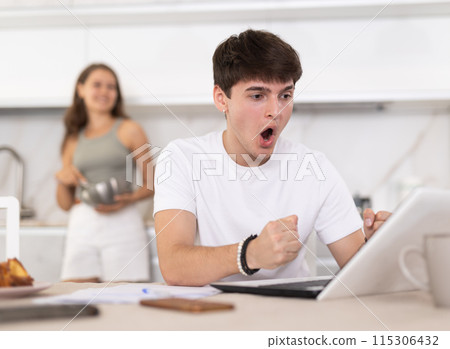 Young woman smiling and chatting with guy working at laptop Young woman smiling and chatting with guy working at laptop 115306432