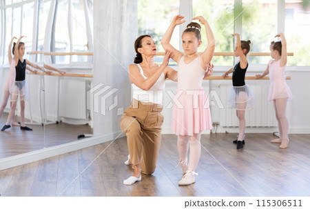 Woman teacher corrects movement of girl dancer 115306511
