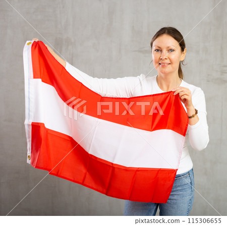 Happy smiling woman proudly displaying austrian flag Happy smiling woman proudly displaying austrian flag 115306655