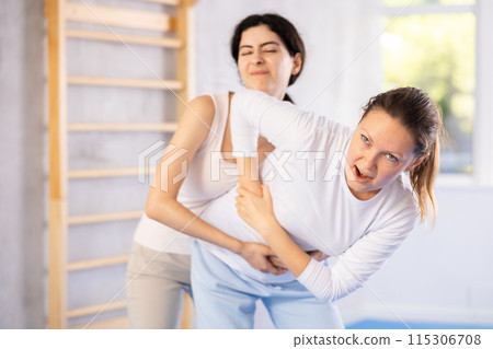 Two women training self-defense techniques in studio 115306708