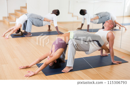 Athletic korean woman performing paired yoga exercises with male partner Athletic korean woman performing paired yoga exercises with male partner 115306793