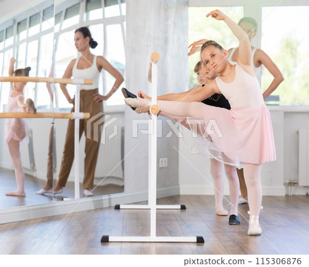 Little ballerinas together with choreography teacher in grand batman pose learn to dance ballet 115306876