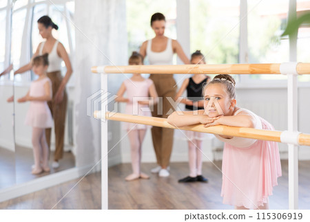Girl dancer resting at ballet barre 115306919