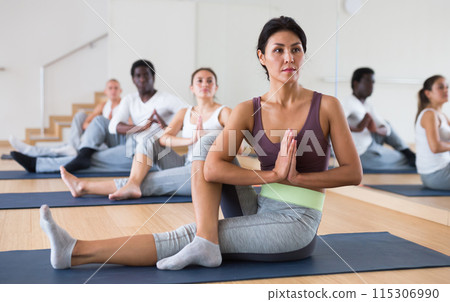 Young woman practicing yoga at group class 115306990