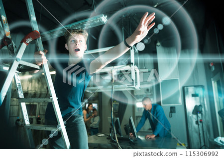 Teenage boy tries to find a solution to a puzzle in the quest room 115306992