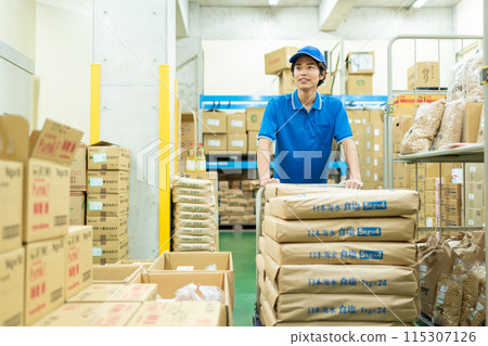 Young male driver working in warehouse 115307126
