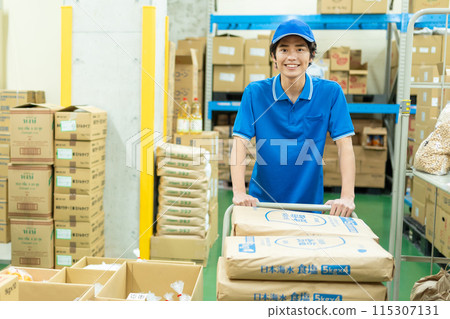 Young male driver working in warehouse Young male driver working in warehouse 115307131