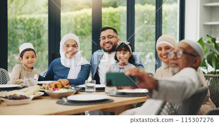 Muslim, family and eating food with selfie for eid mubarak in living room of house for celebration. Islamic, memory and festival with dinner in lounge of home for culture or tradition after ramadan Muslim, family and eating food with selfie for eid mubarak in living room of house for celebration. Islamic, memory and festival with dinner in lounge of home for culture or tradition after ramadan 115307276