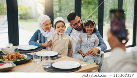 Muslim, phone and photography with family lunch for eid mubarak in living room of house and celebration. Islam, mobile and memory with dinner in lounge of home for culture or festival after ramadan 115307337