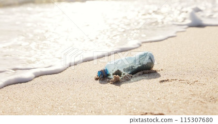 Beach, ocean and plastic bottle in sand for pollution, litter and trash in sea for global warming crisis. Nature, climate change and closeup of garbage in sea to reduce waste, recycling and cleaning Beach, ocean and plastic bottle in sand for pollution, litter and trash in sea for global warming crisis. Nature, climate change and closeup of garbage in sea to reduce waste, recycling and cleaning 115307680